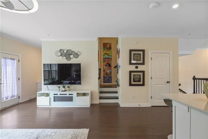 Living room featuring ornamental molding, dark wood-type flooring, and recessed lighting