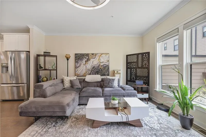 Living area featuring crown molding, wood finished floors, and plenty of natural light