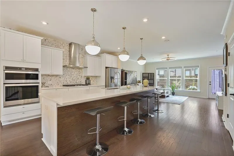 Gourmet Kitchen featuring exhaust hood, stainless steel appliances, dark wood-style flooring, backsplash, and recessed lighting