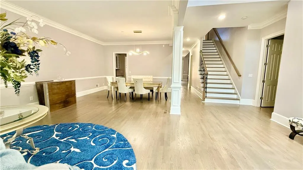 Living and dining room with view of stairs and entrance to the primary bedroom.