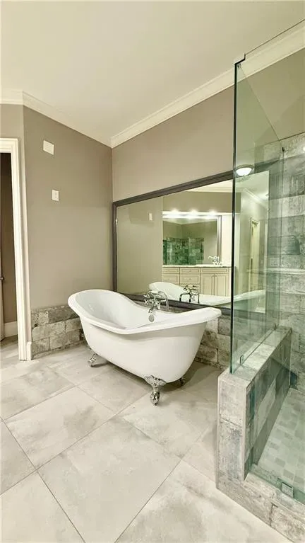 Full bathroom featuring crown molding, a freestanding tub, a stall shower, and tile patterned floors
