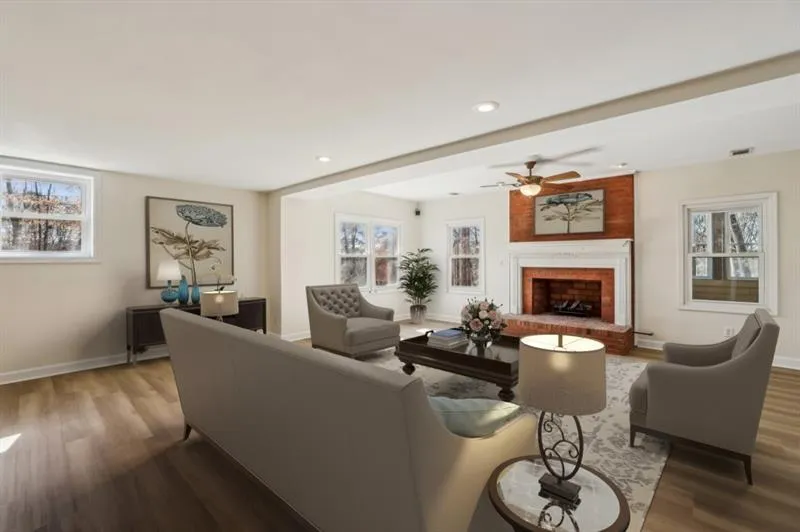 The Daylight Terrace Level expands the living space, boasting a Fireside Family Room with Newly Installed Luxury Vinyl Plank Flooring, a Full Kitchen, and A Sunroom with A Built-In Bar