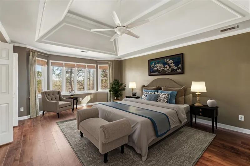 The Luxurious Primary Suite, showcasing Tray Ceilings and A Private Sitting Room, perfect as a Nursery, Additional Closet, Or Home Office