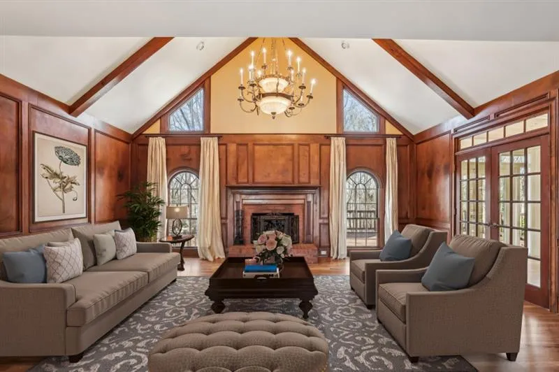 At the heart of the home, the Fireside Family Room is a true showstopper, featuring a Vaulted, Beamed Ceiling, Custom Built-Ins, and Rich Wood-Paneled Walls, creating an atmosphere of warmth and elegance.