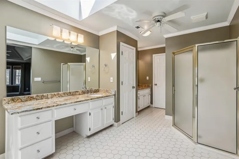 The Spa-Like Ensuite Bathroom features a Soaking Tub, Separate Glass Shower, Double Vanity, And Walk-In Closet.