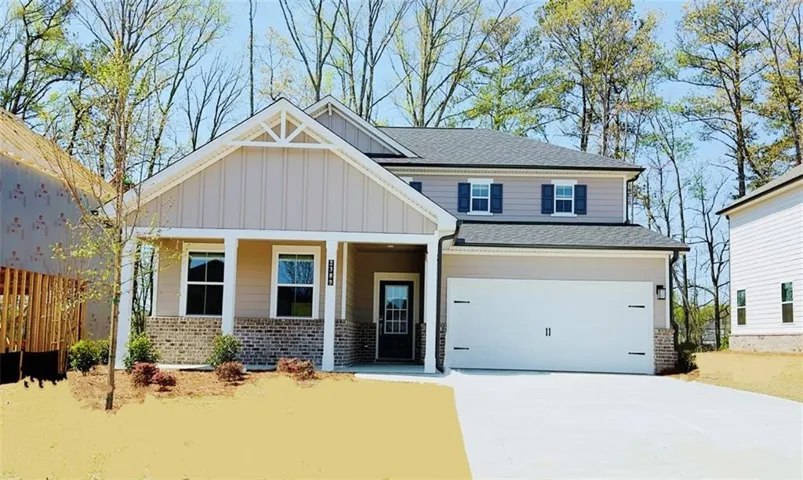 Two-story residence featuring a covered front porch, an attached two-car garage, brick and siding exterior, and a gabled roofline