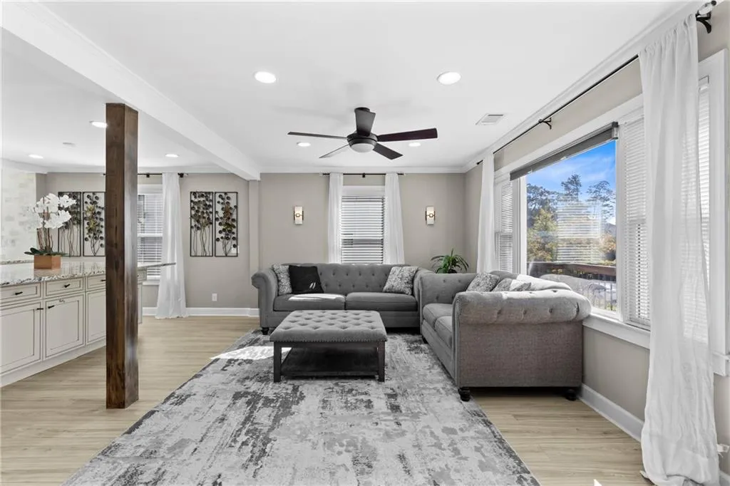 Living area with a ceiling fan, ornamental molding, light wood-style floors, and recessed lighting