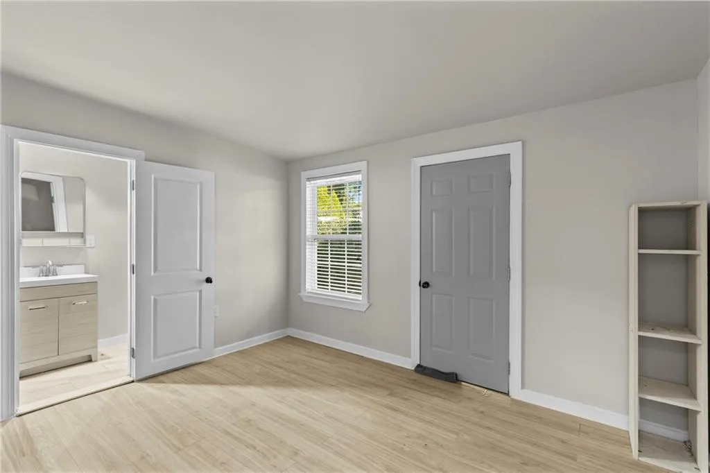 Unfurnished bedroom with light wood-style flooring and ensuite bathroom