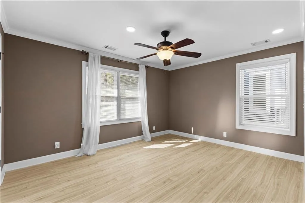 Spare room with ornamental molding, light wood-style floors, a ceiling fan, and recessed lighting