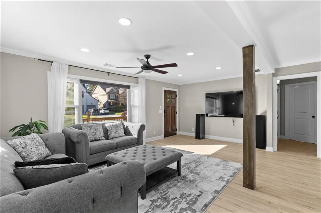 Living area featuring ornamental molding, light wood-style floors, recessed lighting, and a ceiling fan