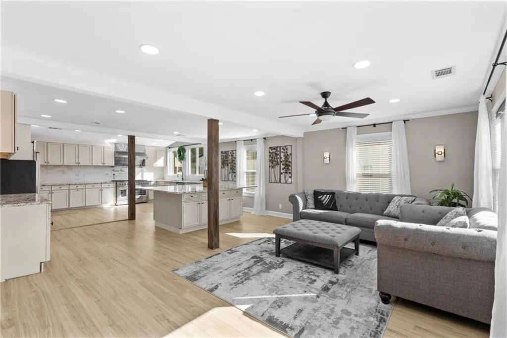 Living area featuring recessed lighting, light wood-style floors, a ceiling fan, and beamed ceiling