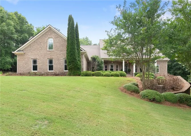 Brick exterior residence featuring a gabled roofline and an arched window