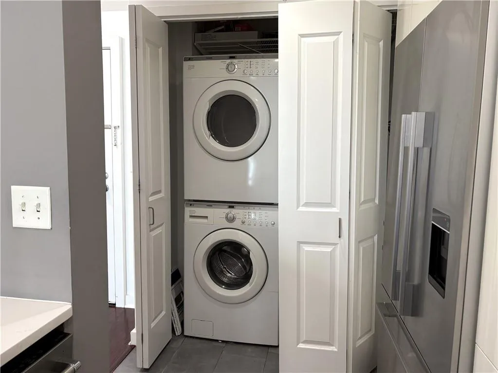 Laundry room off Kitchen featuring stacked Full Size washer and dryer