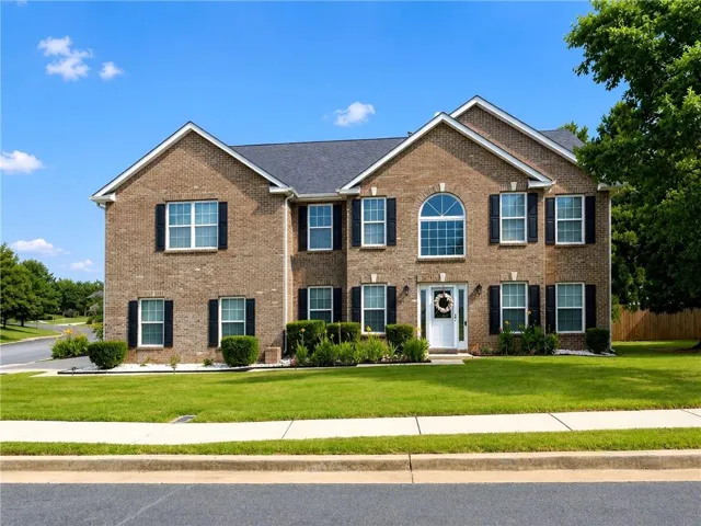 Brick exterior with a gabled roof and dark shingle roofing