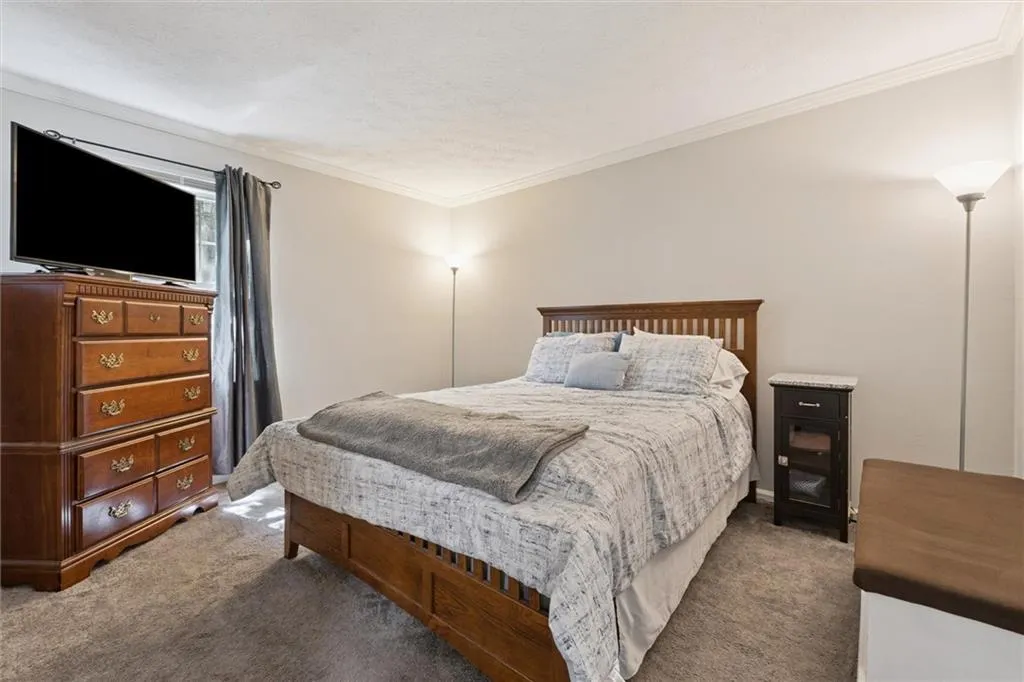Bedroom featuring crown molding, dark colored carpet, and a textured ceiling
