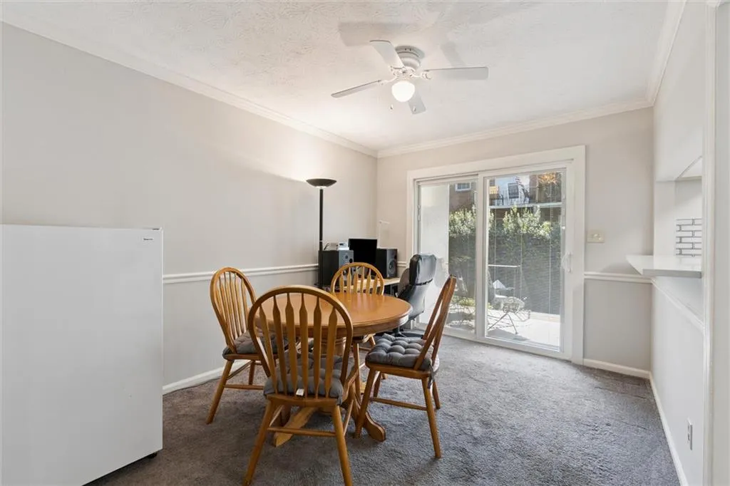 Dining space featuring carpet floors, a textured ceiling, crown molding, and a ceiling fan