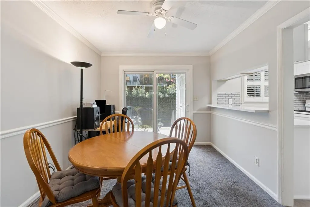 Dining space with crown molding, carpet flooring, and a ceiling fan