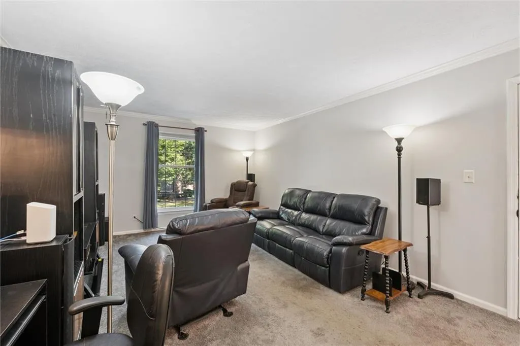 Living room with crown molding and carpet flooring