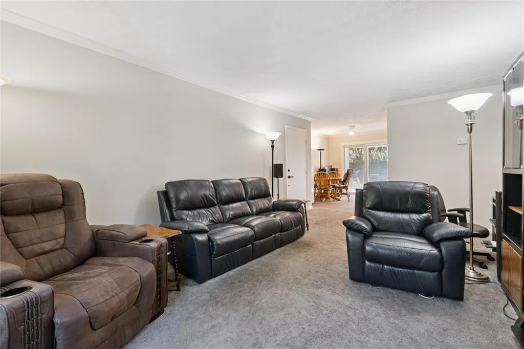 Living area with carpet and ornamental molding