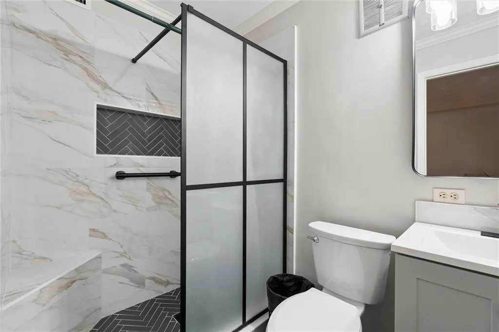 Full bathroom featuring vanity and a marble finish shower