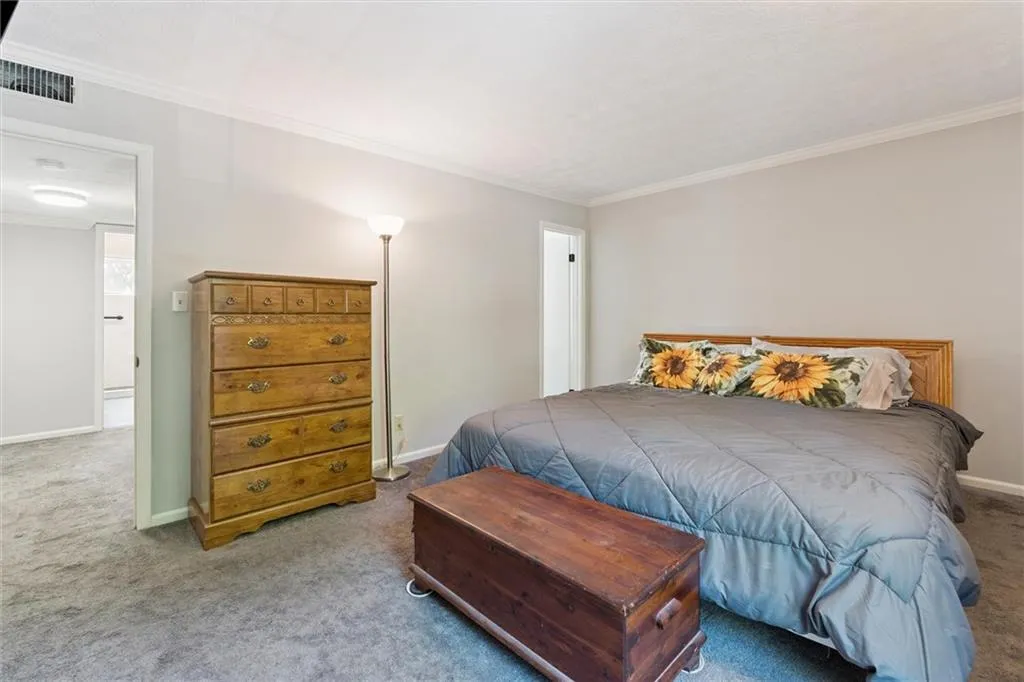 Bedroom with crown molding and carpet floors