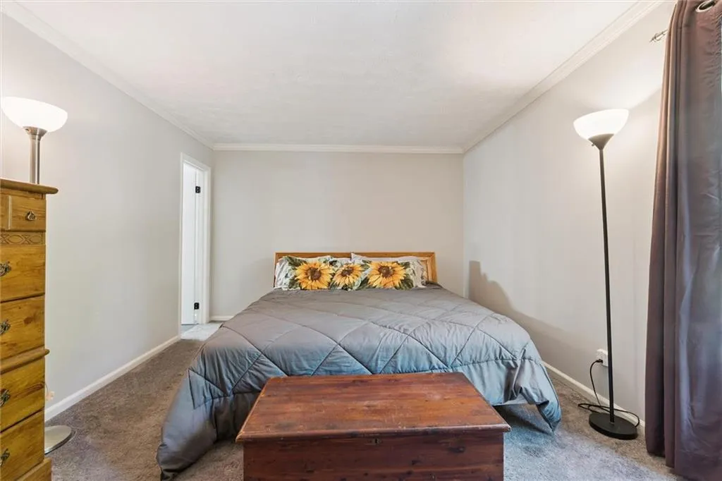 Carpeted bedroom with baseboards and crown molding