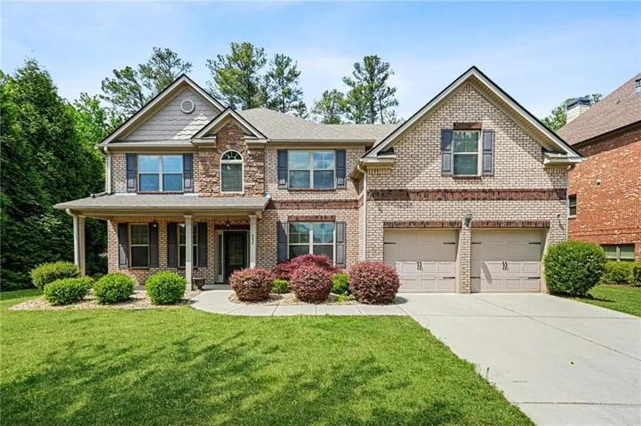 Brick and stone exterior with a covered front porch featuring columns