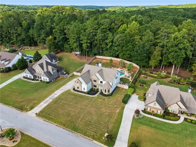 Brick and stone exterior with a neutral roofline, swimming pool, and dedicated driveway