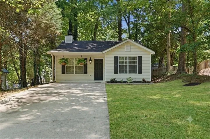 Light-colored siding exterior with a dark roof and black window shutters