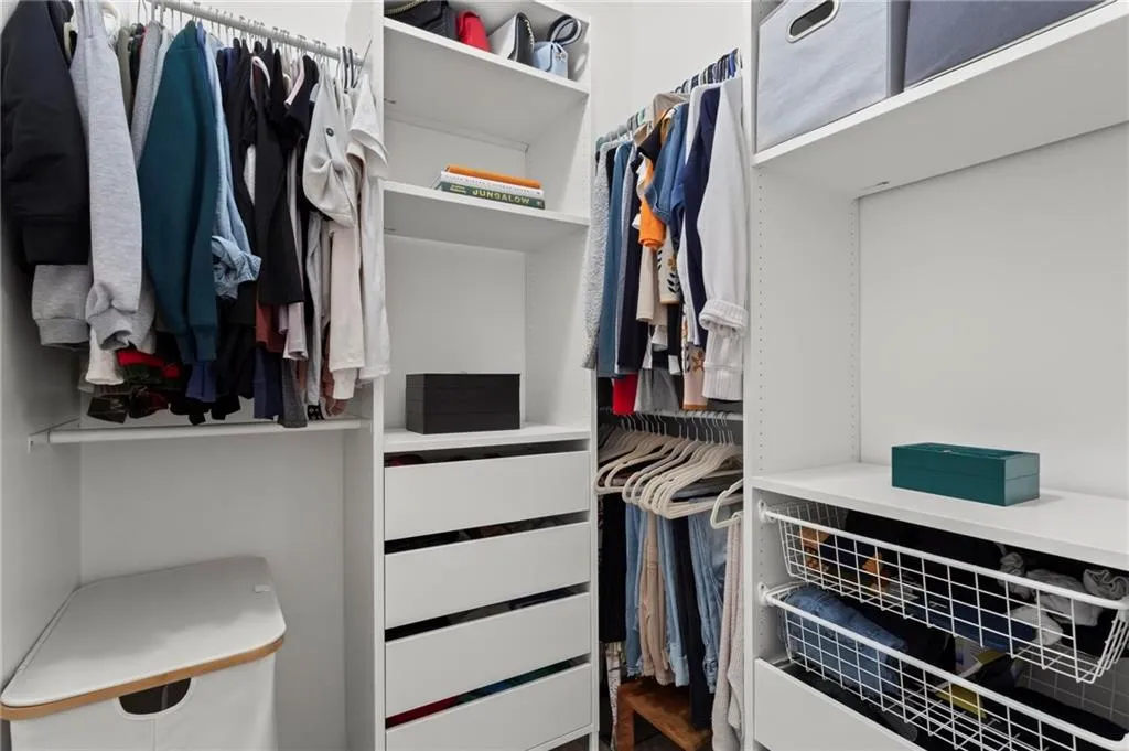 Spacious walk-in-closet with custom system.
