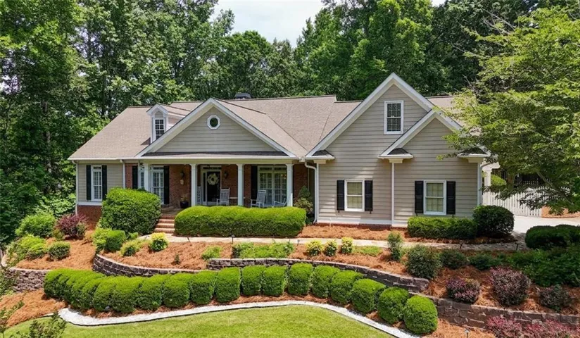 Siding and brick exterior with a covered front porch featuring columns