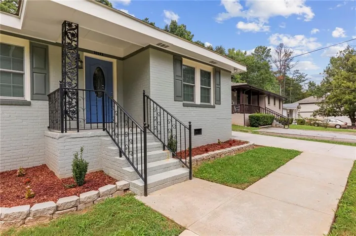 Light gray painted brick exterior with dark gray shutters