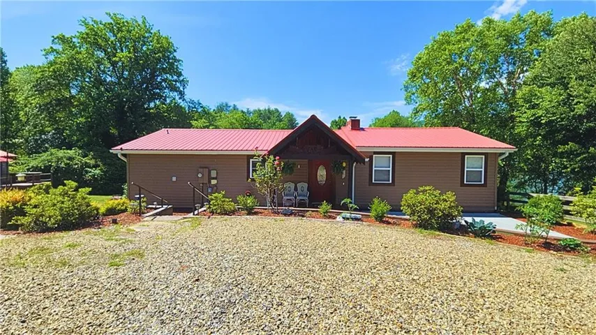 Brown siding exterior with a prominent red metal roof