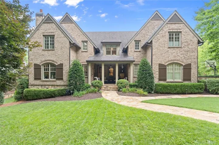 Brick exterior featuring multiple gabled dormers and a covered porch entry