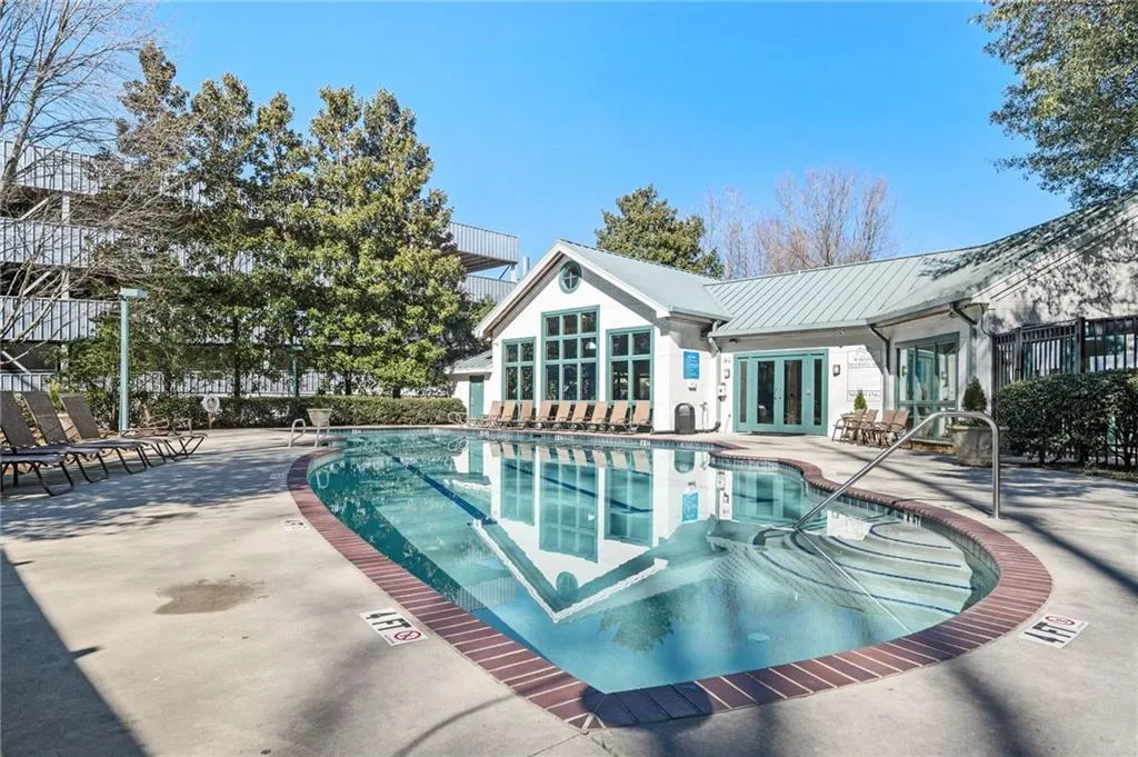 Community pool with french doors and a patio