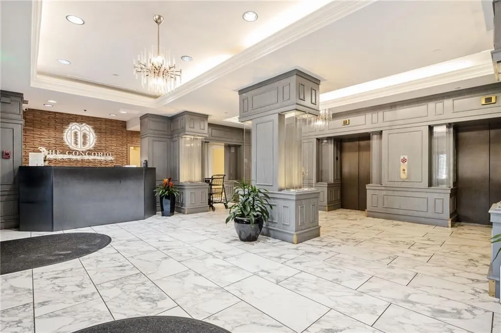 Reception with a chandelier, ornamental molding, and recessed lighting