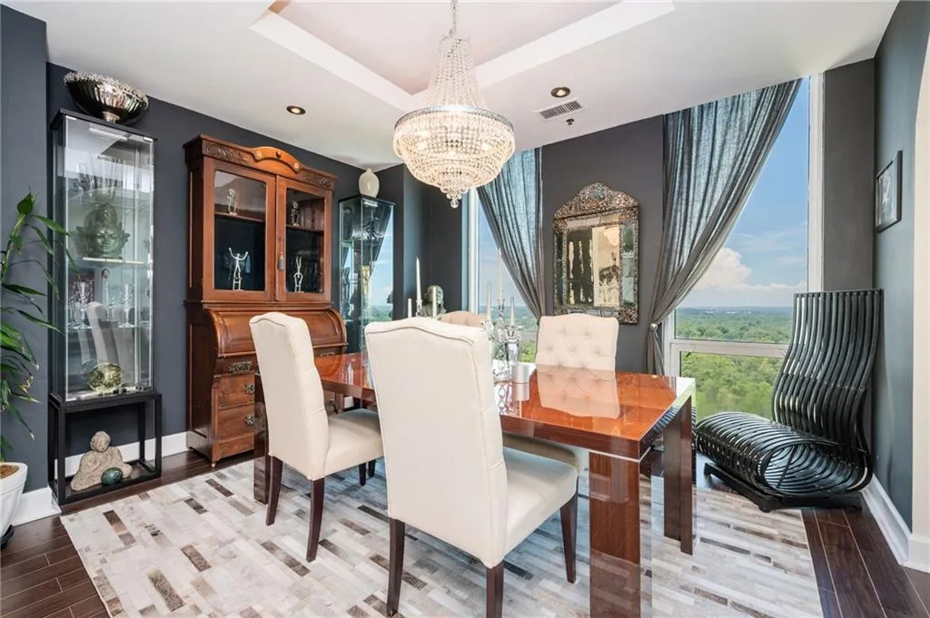 Dining room with a wood floors, a raised ceiling, and recessed lighting
