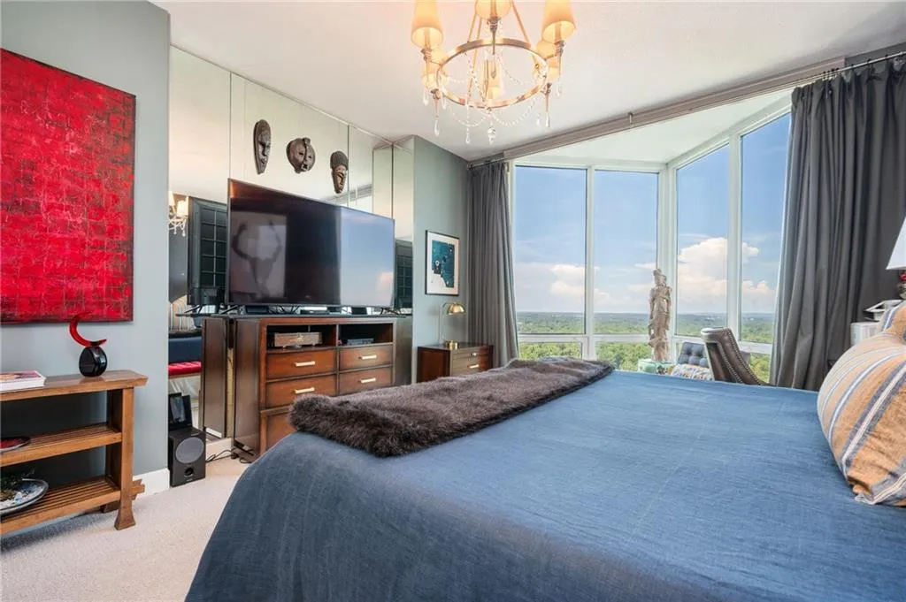 Bedroom featuring floor to ceiling windows, a chandelier