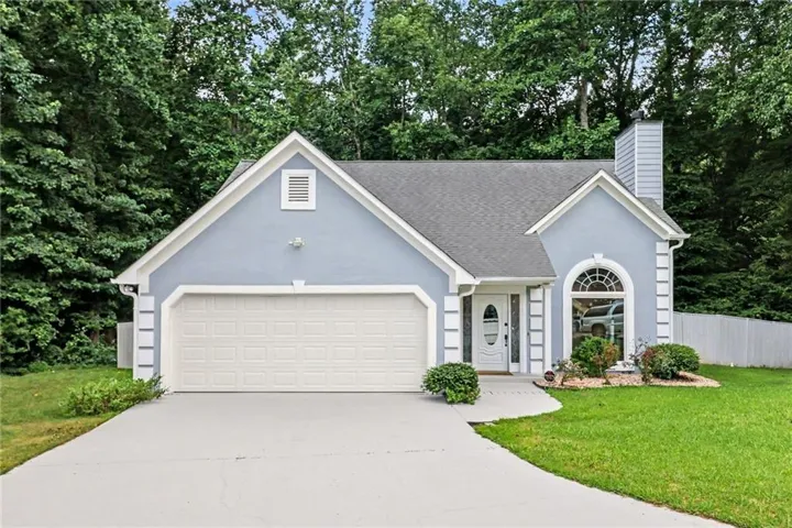 Light blue stucco exterior with a prominent two-car garage