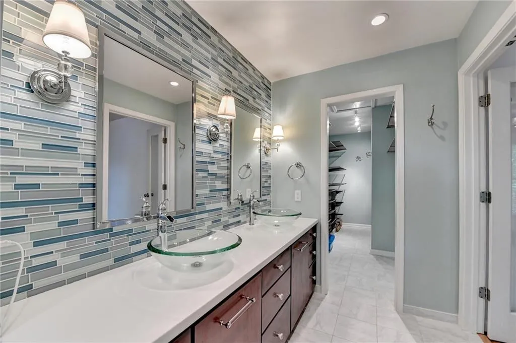 Full bathroom with double vanity, tasteful backsplash, and recessed lighting