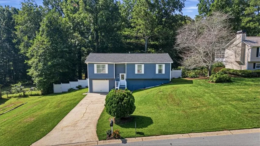 Split-level residence featuring blue siding, white trim, and a prominent front entry with white railings