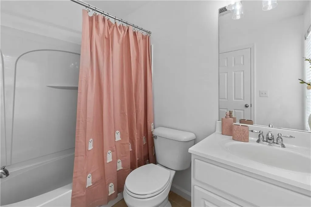 Second-floor ensuite bath features a shower / tub combo with vanity and natural light.