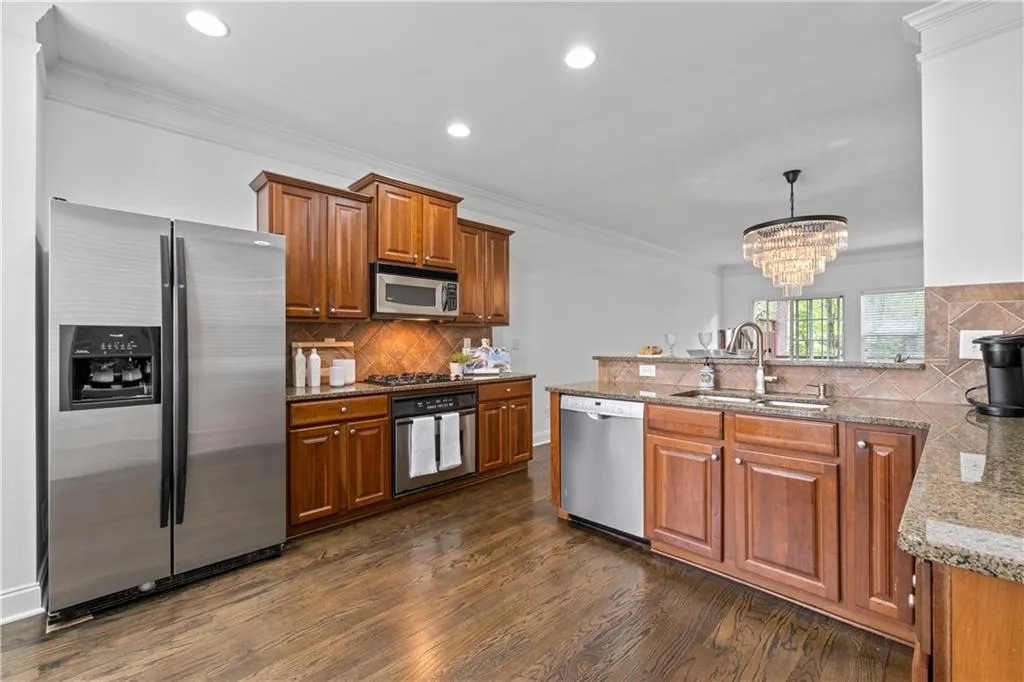 Spacious kitchen with stainless steel appliances, hardwood floors and beautifully stained wood cabinets. Dining is easy with quick access between kitchen and dining rom areas.