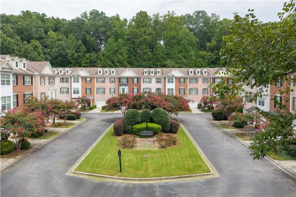 A view of your section of the community and the architectural designed townhomes surrounded by blooming crape myrtles, greenery and wooded areas.