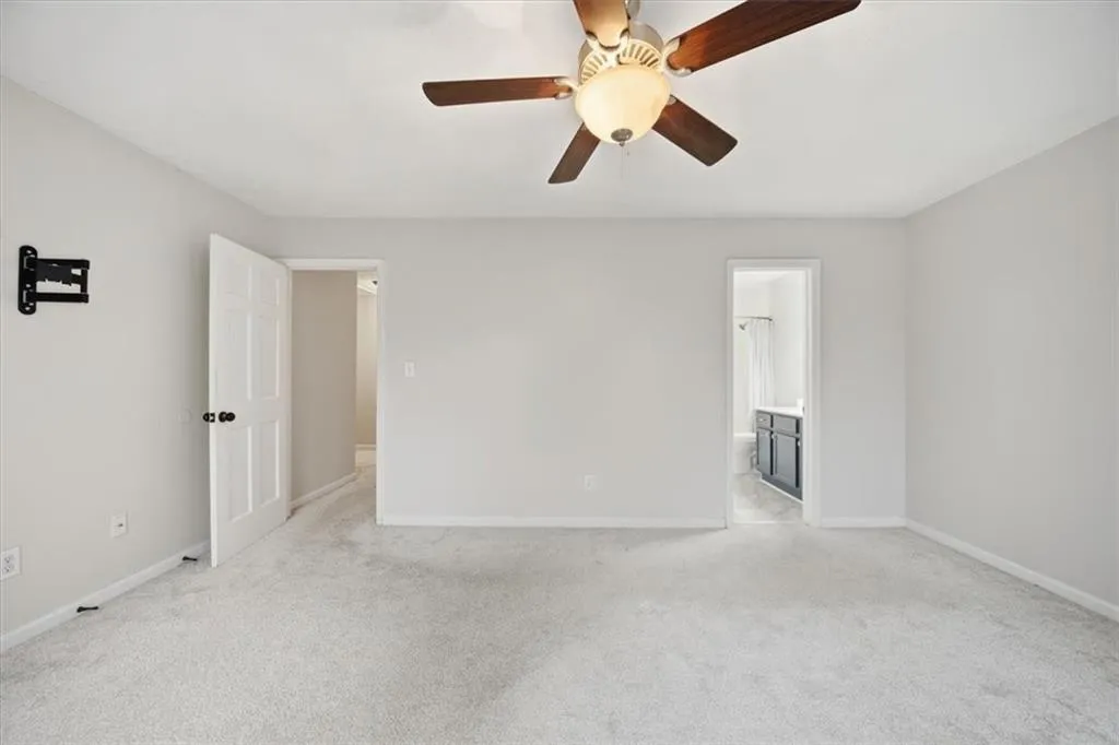 Unfurnished room featuring light carpet and a ceiling fan