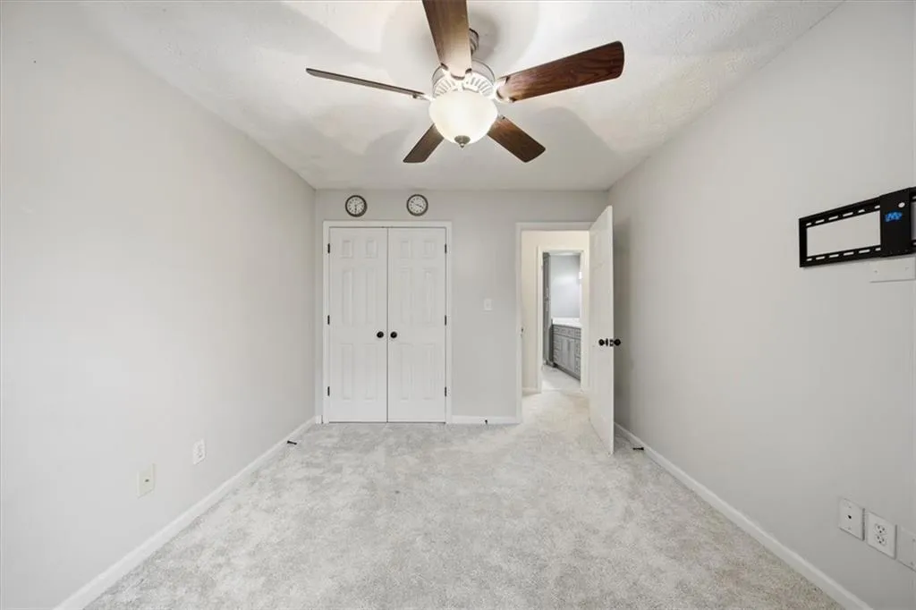 Unfurnished bedroom featuring a ceiling fan, carpet flooring, and a closet