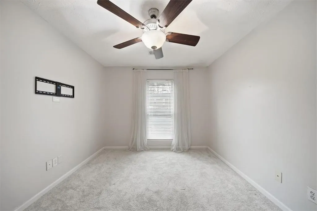 Unfurnished room featuring light colored carpet and ceiling fan