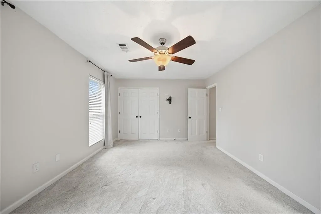 Unfurnished bedroom featuring a ceiling fan, a closet, and carpet