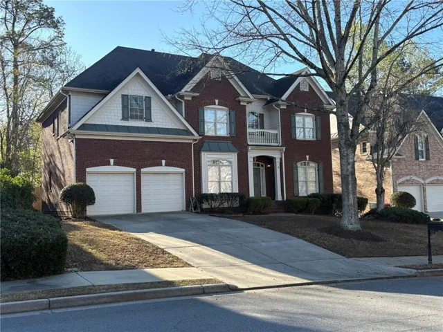 Brick exterior with white trim accents and dark shutters