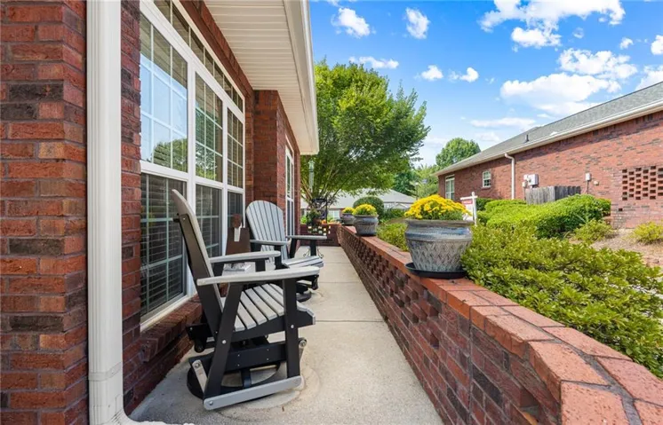 Brick exterior construction with white window frames and a concrete walkway
